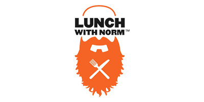 Logo for Lunch With Norm featuring bold black text above an orange graphic of a bushy beard and mustache. Inside the beard, there is a black fork and knife crossed in an X shape.