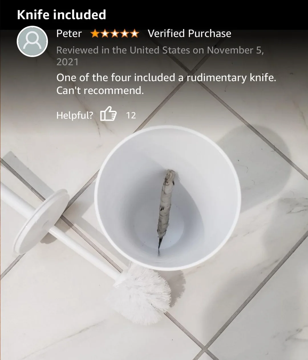 A toilet brush holder on a tiled floor contains a small knife at the bottom. The toilet brush lies next to the holder. The image accompanies a humorous product review mentioning an unexpected included knife.